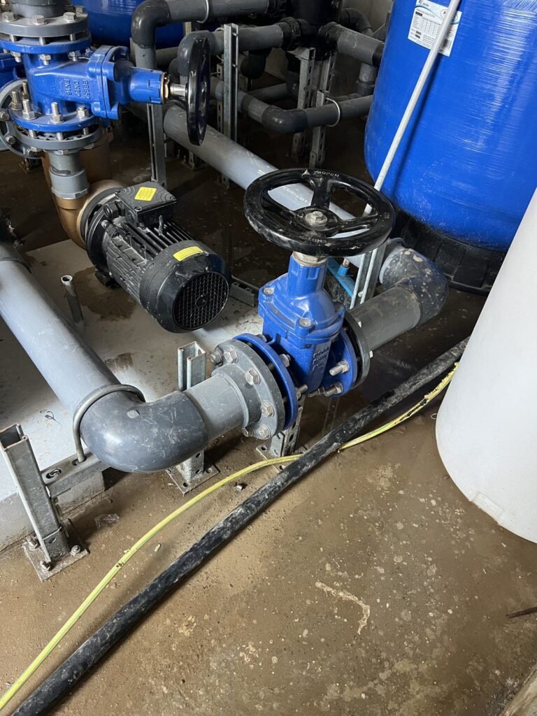 Pump set and gate valve on a concrete plinth in a plant room